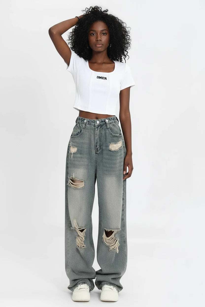 Jean femme rétro américain avec trous, taille haute, coupe droite et ample, design légèrement ajusté, style streetwear tendance, jambes larges et longueur traînante.